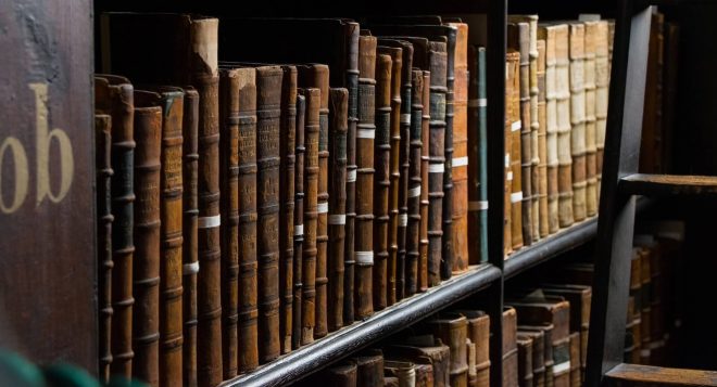 Una estantería clásica de madera en una biblioteca histórica que alberga libros raros y antiguos